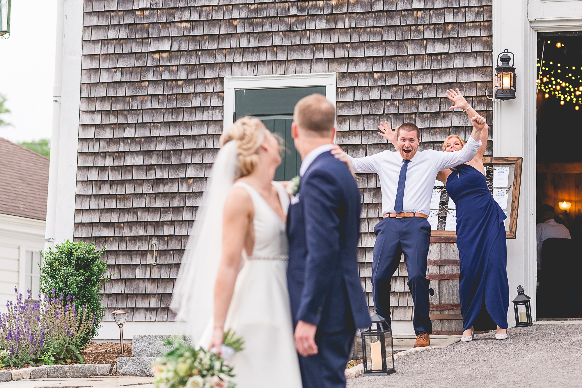 Wedding at Mt Hope Farm in Bristol RI. Bride and groom laughing as two friends cheer behind them.