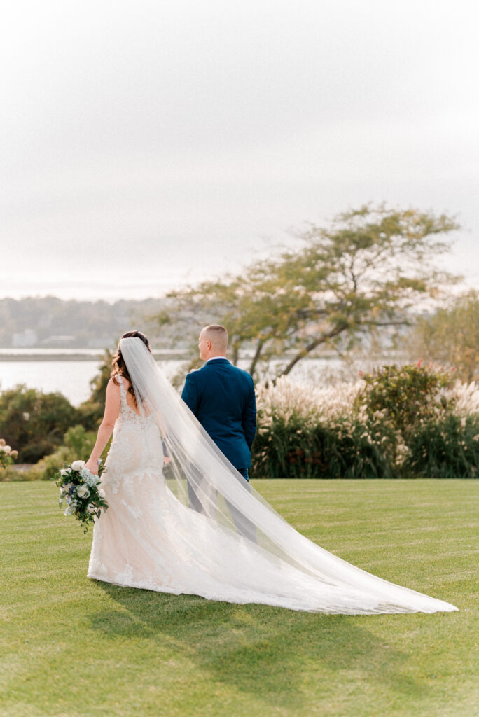 A bride and groom walking across the lawn at Atlantic Resort at Wyndham Newport, Rhode Island.